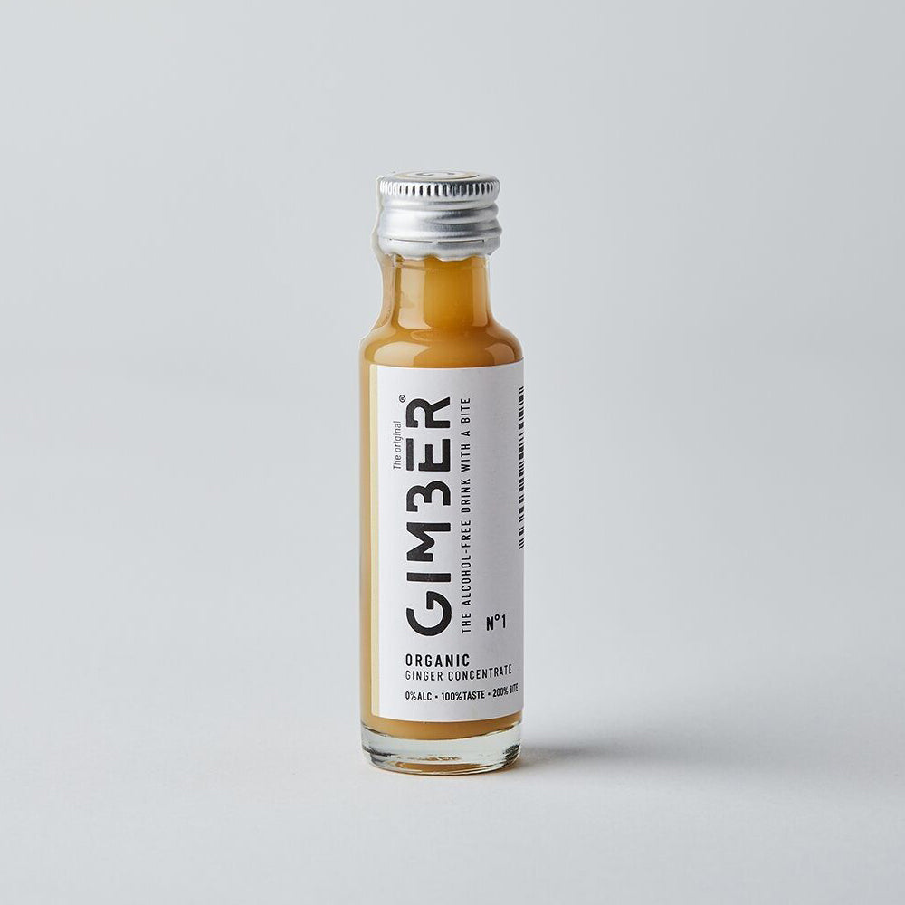 Small bottle of GIMBER organic ginger concentrate on a gray background